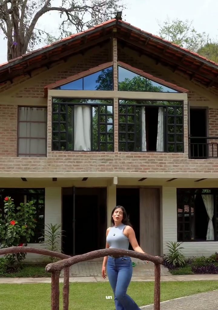 Fachada de una de las cabañas de Wailele rodeada de jardín