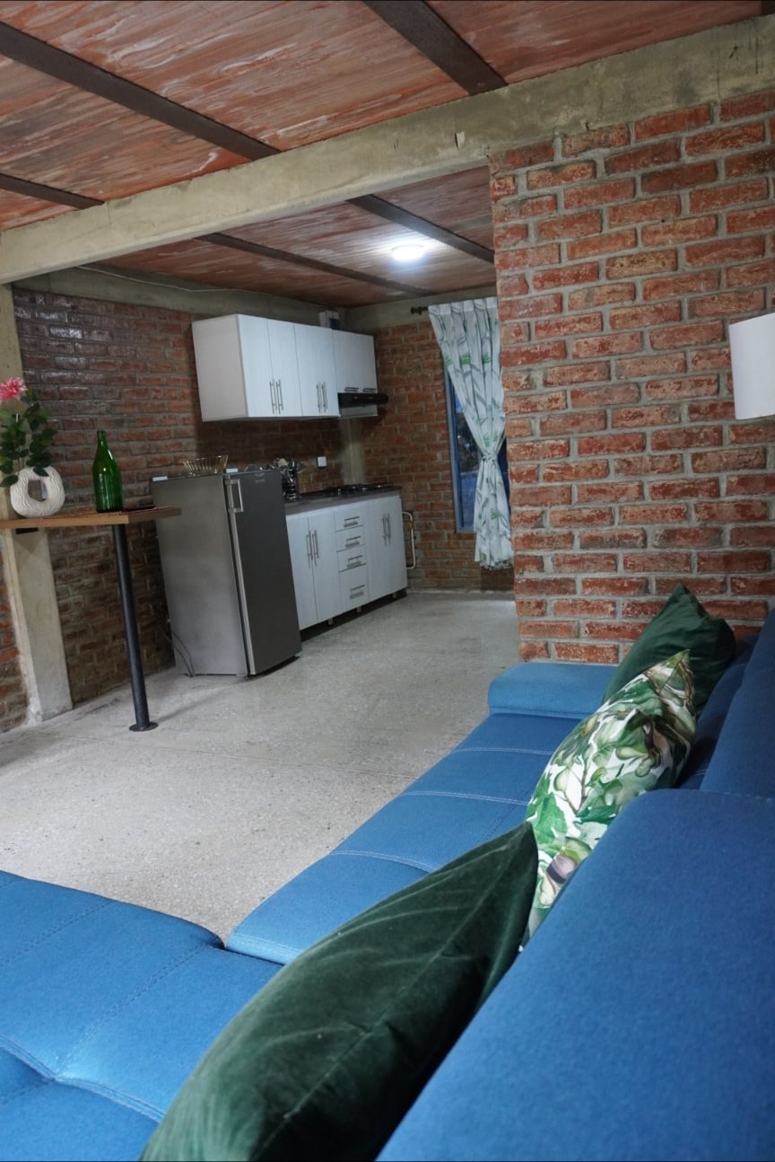 Cocina abierta junto a la sala con sofá azul en Wailele